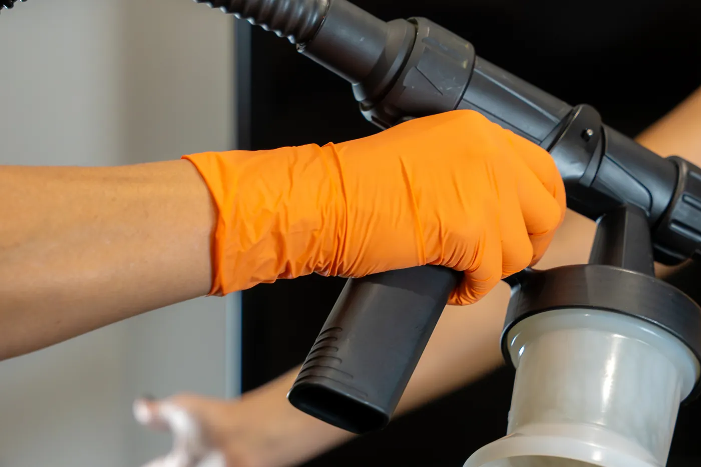 A gloved hand holding the airbrush during a Dolce Glow tan at AWE